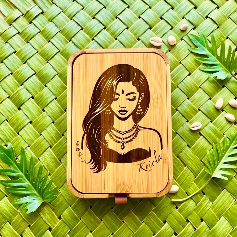 Écrin Héritage Kriola, héritage malbar — coffret en bois gravé d'un portrait de femme aux cheveux longs et bindi, sur natte tressée verte
